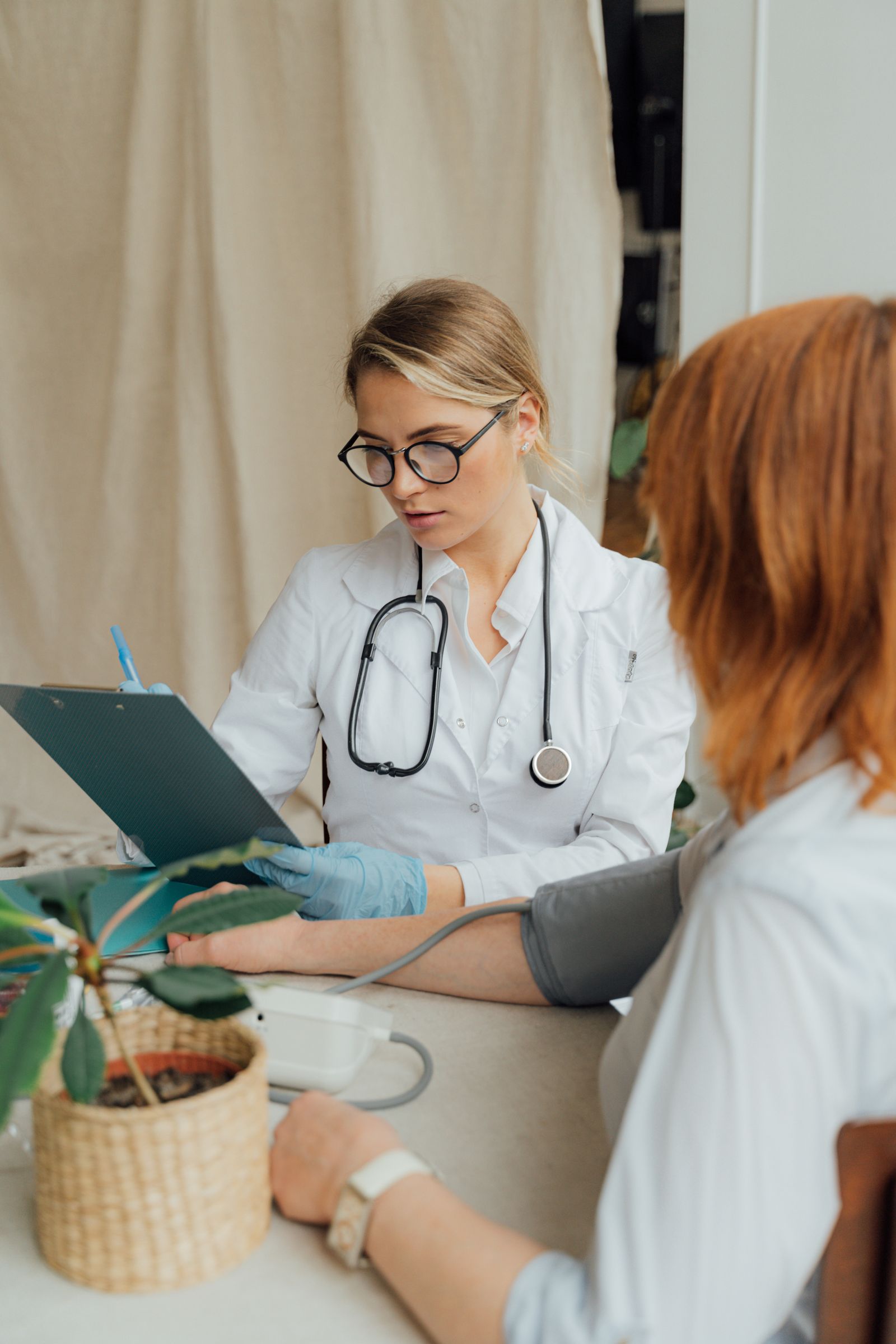 Clinician checking a patient's blood pressure during a consultation