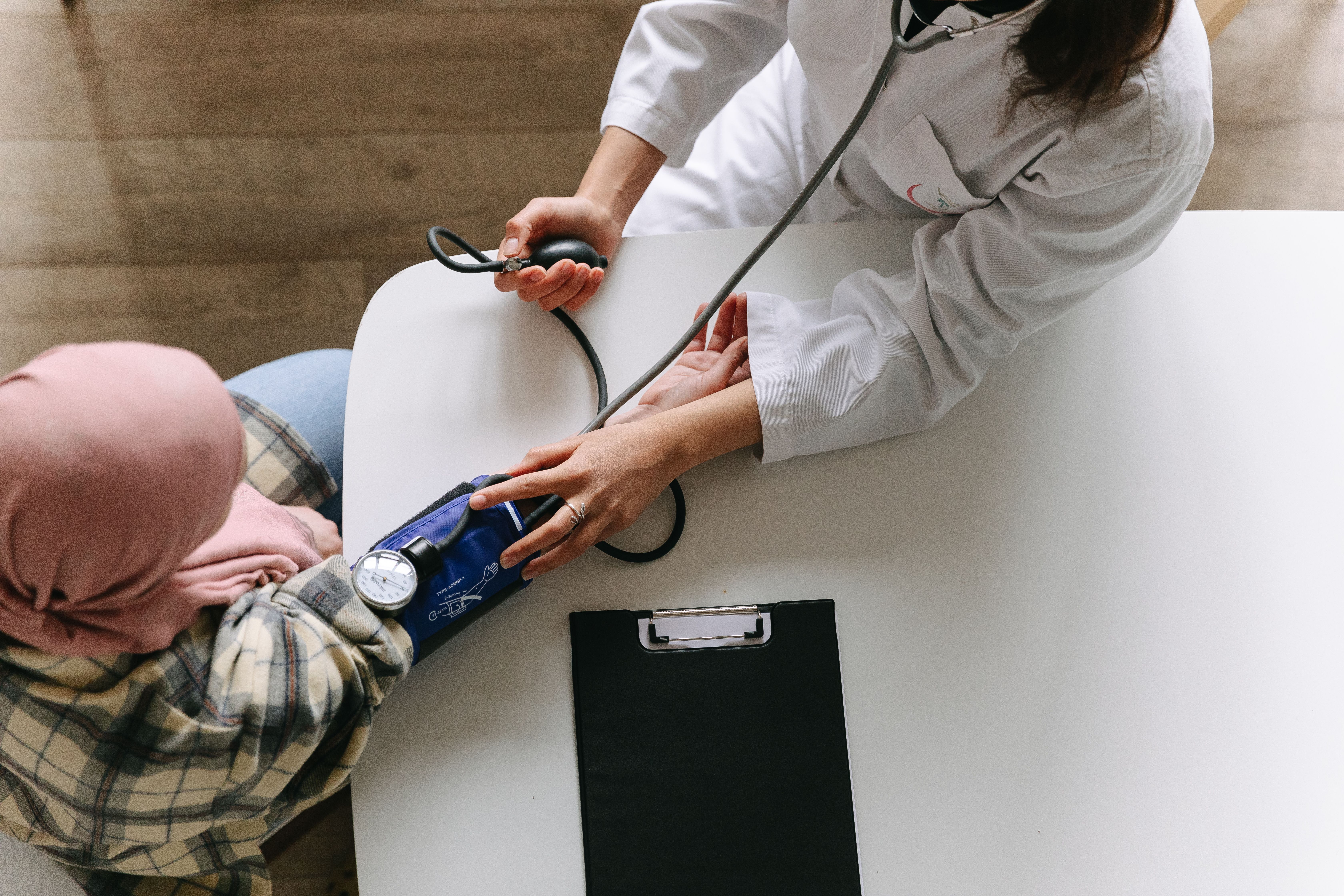Clinician taking an adult patient's blood pressure