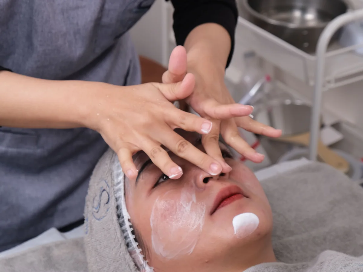 Skincare professional examining a client's skin